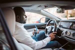 man in white dress shirt driving car during daytime 