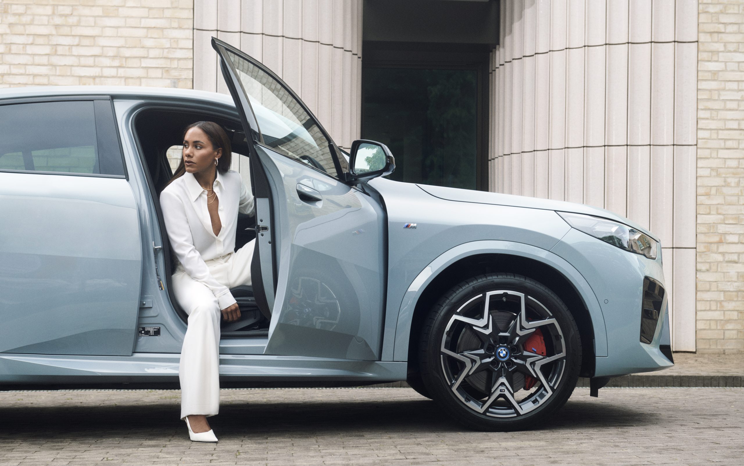 Alex Scott getting out of the BMW iX2 electric car